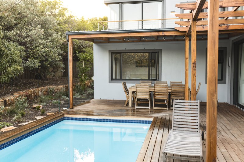 patio exterior con detalles en madera y piscina